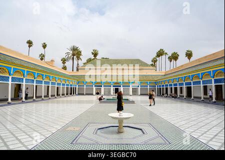Expansive ornate courtyard featuring intricate blue yellow white geometric tiling on walls and floor a central fountain Stock Photo