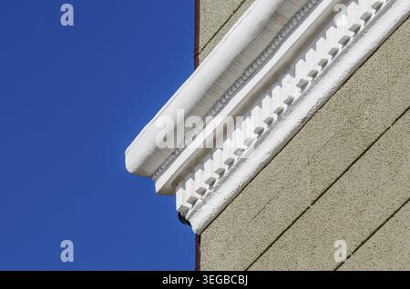 White stucco cornice on a light green plastered cinder block wall Stock Photo