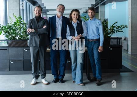 Happy business people team standing together in office, group portrait. Smiling professional employees company staff with older executive leader look Stock Photo