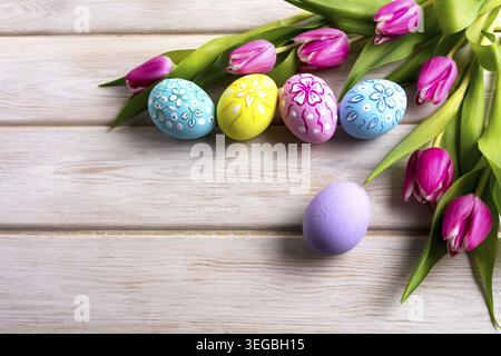 Easter hand painted floral decorated eggs with pink tulip flowers. Happy Easter greeting card or invitation. Copy space Stock Photo