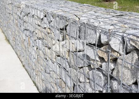 Detail of a gabion wall made of granite stones and wire mesh used for landscaping Stock Photo
