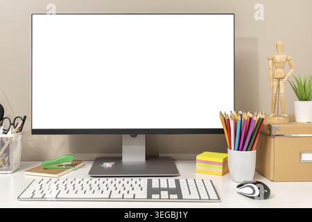 Workspace showing computer with white blank screen, keyboard, mouse and various stationery items, ideal for designers, students or creative workers. T Stock Photo