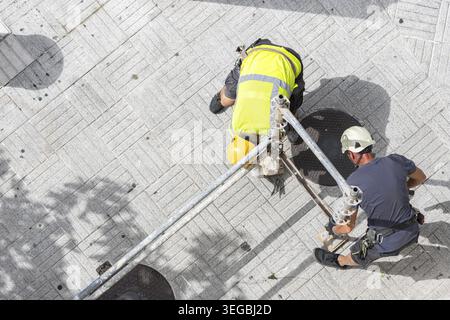 Overhead view of two workers in protective workwear assembling scaffolding Stock Photo