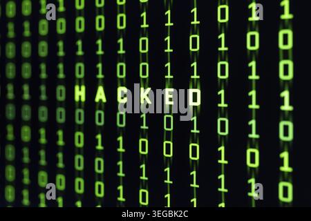 Hacked word on binary code background of a computer screen Stock Photo