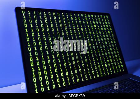Computer Hacked concept. Laptop screen with hacked word and binary code background Stock Photo