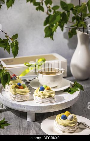 Easter Pavlova nests with chocolate eggs and coffee Stock Photo