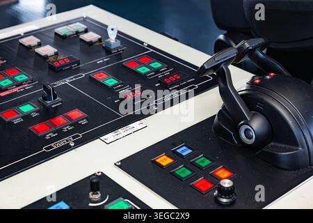 Industrial machinery remote control panel with buttons indicators and dual joystick throttle on a ship bridge or command center Stock Photo