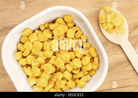 Sweet corn kernels in bowl on wooden table still life Stock Photo