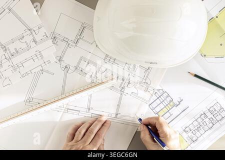 Top view of an architect hands working on Architecture plans on desk Stock Photo