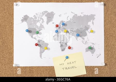 My next travel destination concept. Pushpins on world map on Corkboard and yellow sticky note Stock Photo