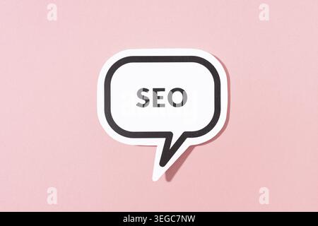 SEO text on speech bubble isolated on pink background Stock Photo