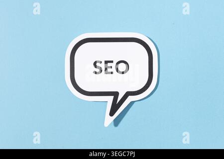 SEO text on speech bubble isolated on blue background Stock Photo