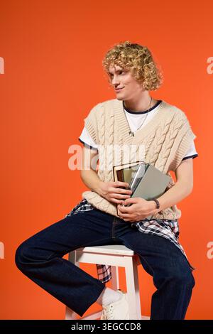 Blonde curly haired student showcases trendy casual style while posing in a studio setting Stock Photo