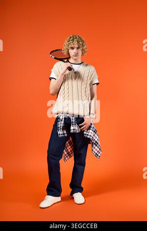 Blonde, curly haired young man showcases trendy student fashion in a bright studio setting. Stock Photo