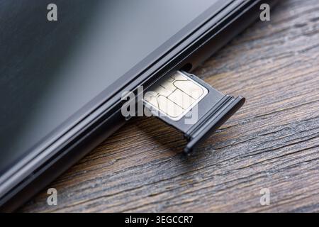 Inserting a modern nano SIM card into a Smartphone Stock Photo