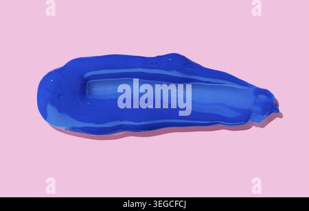 Blue paint Brush Stroke isolated on pink background. Acrylic paint Stock Photo