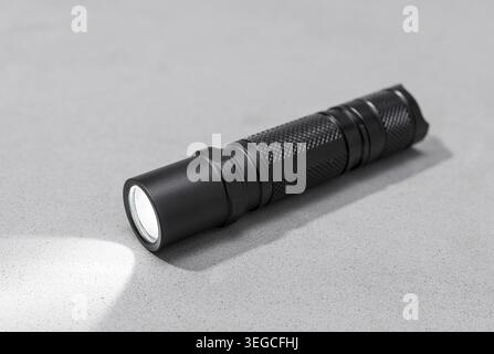 Modern aluminum Led Pocket Flashlight switch on isolated on gray background Stock Photo