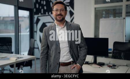 Caucasian business man smiling looking at camera businessman unbutton button on stylish formal jacket posing in office middle-aged happy satisfied Stock Photo