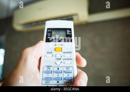 Air conditioner temperature adjustment with remote controller in room at home Stock Photo