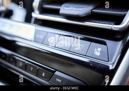 Modern car detailing climate control panel showing MAX AC, air circulation, and heated seat buttons with air vent and programmable shortcuts, highligh Stock Photo