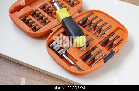 Multi-bit hardware toolkit with various attachment heads on a tabletop. Practical equipment package for DIY home improvement and fixing construction w Stock Photo