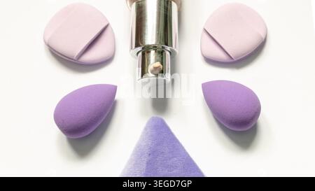 Beauty blenders and liquid foundation arranged on white background. Stock Photo
