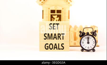 Set smart goals words symbol. Concept words Set smart goals on beautiful wooden blocks. Beautiful white background. Black alarm clock. Business and se Stock Photo