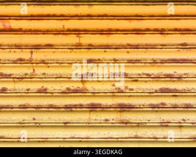 Rusty metal security shutter on an urban building exterior. UK Stock Photo