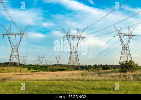 An energy infrastructure network featuring massive steel towers for high voltage lines Stock Photo