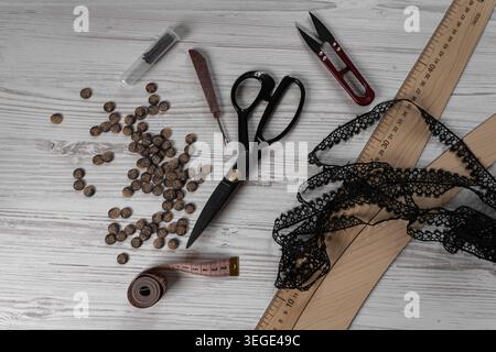 Collection of sewing tools and tailoring accessories including scissors, measuring tape, ruler, threads and buttons arranged on table. Concept of hand Stock Photo