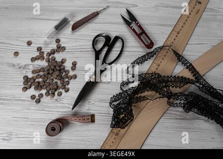 Collection of sewing tools and tailoring accessories including scissors, measuring tape, ruler, threads and buttons arranged on table. Concept of hand Stock Photo