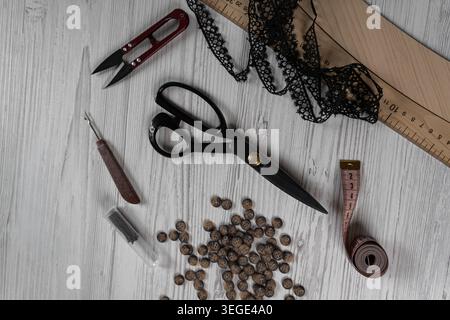 Collection of sewing tools and tailoring accessories including scissors, measuring tape, ruler, threads and buttons arranged on table. Concept of hand Stock Photo