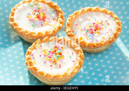 Mr. Kipling Birthday Cake Tarts, featuring white fondant icing topped with coloruful candy sprinkles Stock Photo