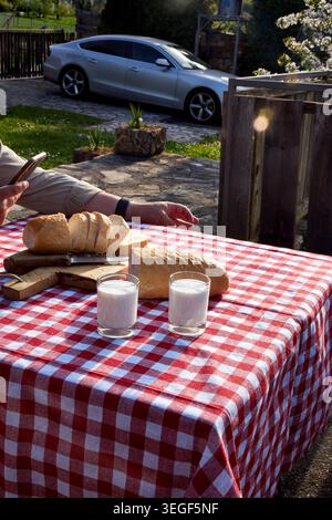 Man Using Smartphone During Rustic Countryside Breakfast Stock Photo
