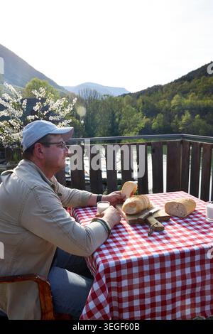 Man Using Smartphone During Rustic Countryside Breakfast Stock Photo