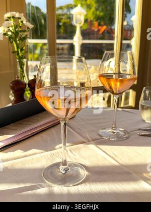 Two glasses of rose wine on a window table in a hotel restaurant Stock Photo