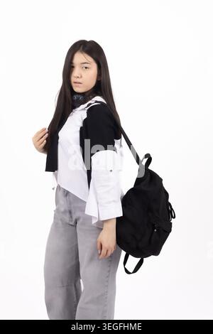 Young stylish woman standing with a black backpack in studio Stock Photo