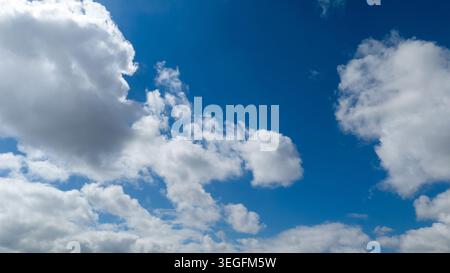 Beautiful clear blue sky background filled with fluffy white clouds Stock Photo