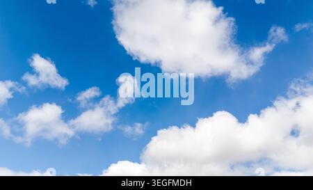Bright blue summer sky texture filled with white scenic clouds Stock Photo