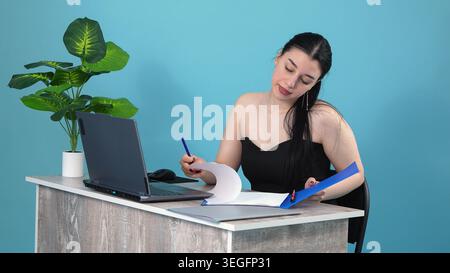Concentrated business woman reading financial report document at desk Stock Photo