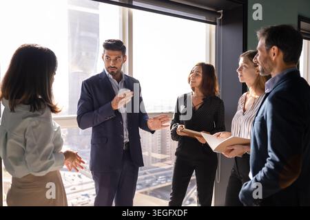 Diverse businesspeople discussing strategy in corporate office Stock Photo