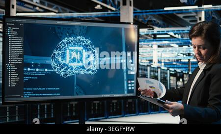 Data center engineer using artificial intelligence tech to monitor industrial automation systems. Server room IT expert using AI machine learning to oversee network performance Stock Photo