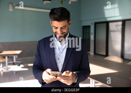 Adult businessman checking smartphone in corporate office Stock Photo
