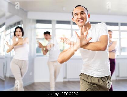 Guy with team of young like-minded people learn to dance modern dances Stock Photo
