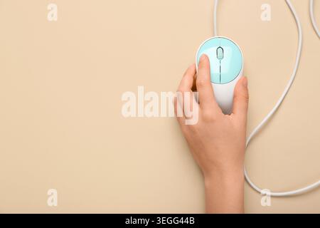 Female hand with modern computer mouse on beige background Stock Photo