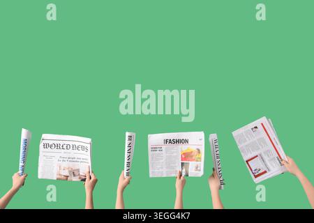 Women with newspapers on green background Stock Photo