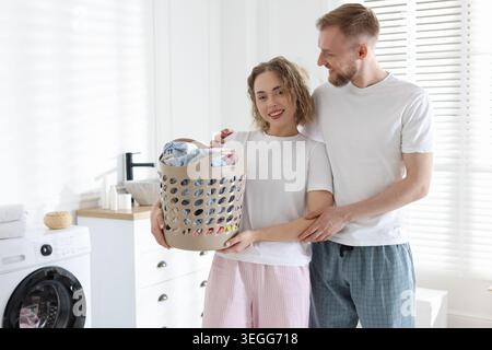 Happy couple doing laundry together at home Stock Photo