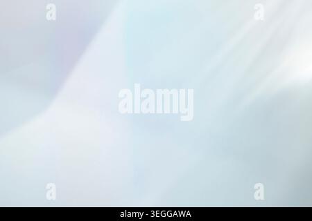 Soft diagonal sunbeams illuminating a pale blue background Stock Photo