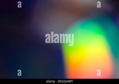 Abstract dark backdrop with a bright green and yellow blurred orb Stock Photo
