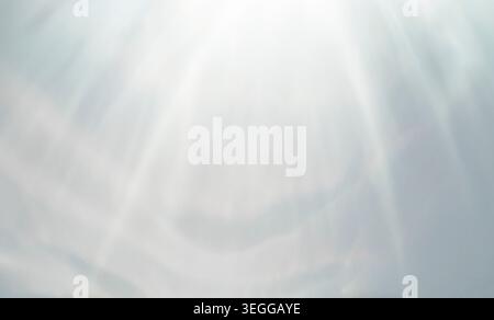 Heavenly bright light rays shining down on a soft white and gray abstract blurred background Stock Photo